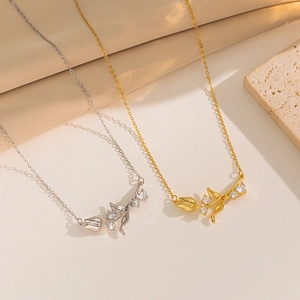 Elegant gold and silver tulip pendant necklaces with zircons on a textured stone
