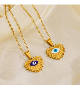 Close-up of golden evil eye heart necklaces on beige silk fabric with relief details