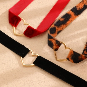Dettaglio di collane in velluto rosso e nero con stampa leopardata e fibbie a cuore