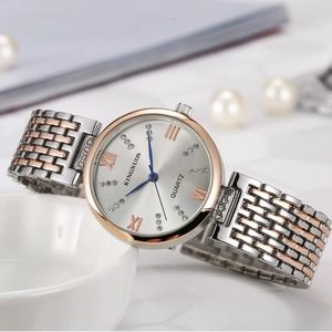 Fashionable women's watch with two-tone steel band and diamond accents on a pearl background