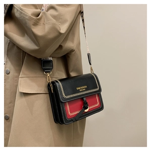 Detail shot of black and red PU leather crossbody bag with chic wide shoulder strap