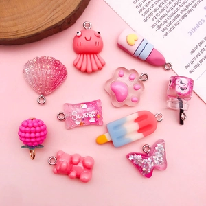 Detail of DIY pink resin charms featuring glitter shells, bears and sweet candy shapes