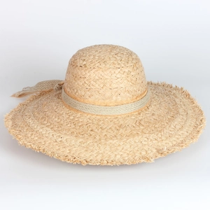 Beige wide-brim raffia straw sun hat with fringe edges and side bow for beach vacation