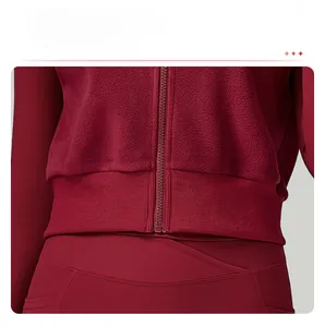 Détail de l'ourlet élastique côtelé et du zip d'un gilet de sport en polaire bordeaux