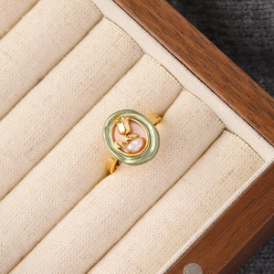 Detail of tulip enamel ring with a white pearl and gold finish in a luxury box