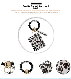 Detail of silicone bead bracelet and PU leather card holder with black dog paw prints