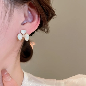 Close-up of 18k gold plated flower stud earring with mother of pearl petals on a model