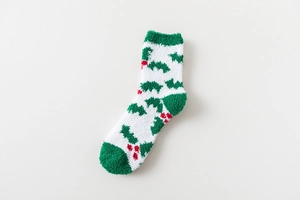 Detailed view of plush Christmas socks with holly leaf pattern and warm coral fleece texture
