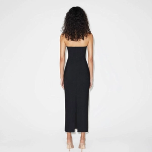 Detail showing the back view of a slim fit black halter dress with a stylish rear slit
