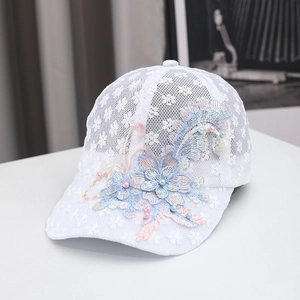 Dettaglio cappellino in pizzo bianco con ricami floreali pastello e perle colorate