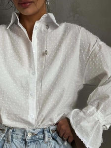 White polka dot cotton blouse with lace cuffs and flared sleeves for a chic spring look