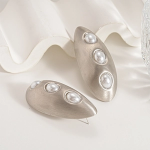 Matte silver oval earrings with three vertical pearls and a brushed metal finish