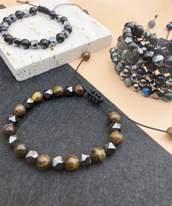 Macro shot of faceted hematite and tiger eye beads with adjustable braided cord detail