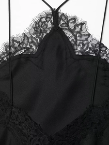 Detail van zwart kantwerk en gladde satijnen stof op de camisole jurk voor dames