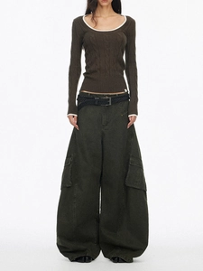 Detail of slim fit cable knit sweater with white trim neckline and green cargo pants