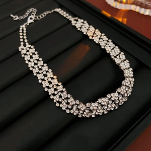 Détail macro du collier ras de cou argenté à plusieurs rangs serti de strass avec fermoir