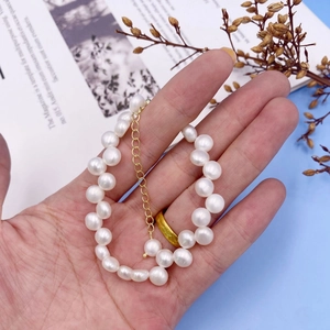 Close-up of a white freshwater pearl bracelet with a golden adjustable extension chain