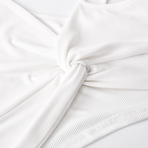 Dettaglio del nodo intrecciato su questo crop top bianco a coste monospalla