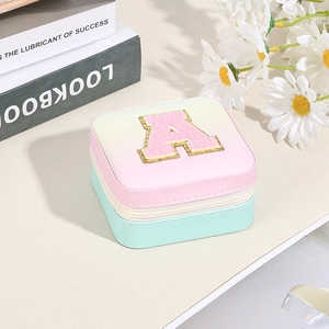 Square gradient pink and green jewelry box with gold letter A patch and zipper closure