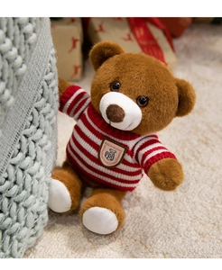 Gros plan d'un ours en peluche marron portant un pull tricoté à rayures rouges et blanches