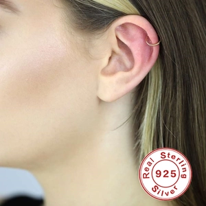 Close-up of a minimalist 925 sterling silver hoop earring on ear cartilage