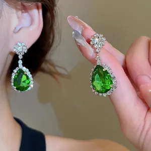 Elegant silver pear-shaped emerald drop earrings with sparkling diamond halo accents