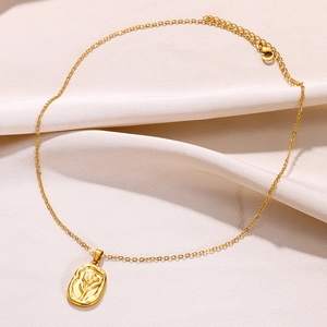 Gros plan du collier en acier doré avec pendentif ovale orné d'une rose en relief vintage