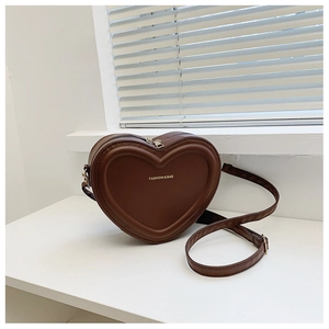 Dettaglio della borsa in pelle marrone caffè a forma di cuore con scritte dorate