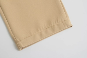 Dettaglio macro del tessuto intrecciato kaki con cuciture premium e orlo dei pantaloni