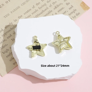 Detailed macro view of two golden star-shaped DIY jewelry charms on a white stone