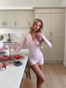 Tuta slim fit a fiori rosa con maniche lunghe e bottoni frontali in cucina moderna