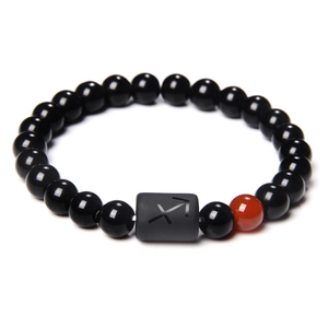 Detailopname van de Boogschutter sterrenbeeld armband met zwarte kralen en rode accent