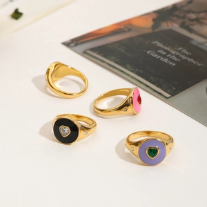 Detailed shot of gold-plated stainless steel heart rings with colorful enamel and zircons