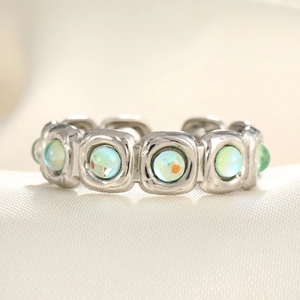 Macro shot of adjustable silver ring with geometric frames and blue-green opals
