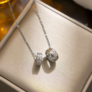 Titanium steel double ring necklace with sparkling zircon crystals on a jewelry box