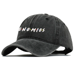 Close-up of ENEMIES embroidery with colorful dots on charcoal washed cotton baseball cap