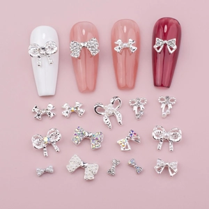Kit bijoux d'ongles en forme de nœuds avec strass et perles sur fond rose