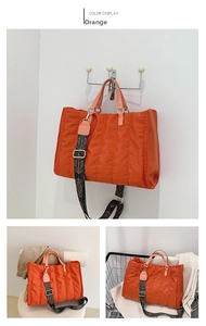 Detail of orange quilted tote bag with ethnic print shoulder strap and large capacity