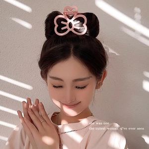 Cute pink butterfly hair claw clip with matte finish on a messy bun hairstyle