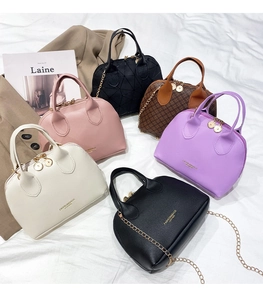 Showcase of shell-shaped handbags in six colors with chain straps on white fabric
