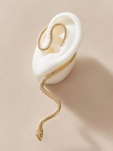 Detail of a golden snake ear cuff featuring sparkling rhinestones on an ear model