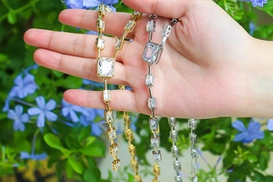Macro shot of long necklaces with rectangular zircons in gold and silver finish