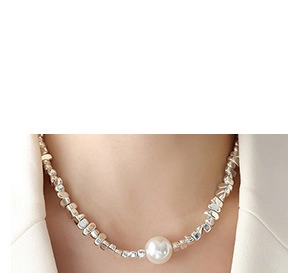 Detailed view of irregular silver beads necklace featuring a large white central pearl