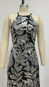Détail de la broderie de paillettes argentées et du licou sur la robe de soirée noire