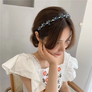 Detail of luxury navy blue crystal beaded headband with floral rhinestone accents on a model