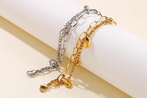 Detail der doppellagigen Kette mit ovalen Perlen und Tropfenanhänger in Gold und Silber
