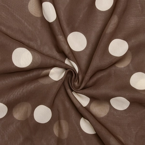 Vue détaillée du tissu en mousseline marron doux avec d'élégants pois blanc cassé