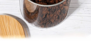 Close-up of high borosilicate glass storage jar with bamboo lid and powder contents