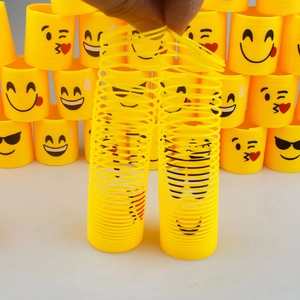 Detail showing hands stretching flexible yellow smiley face spring coils for kids