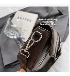 Detail of premium silver hardware and fine stitching on dark brown leather saddle bag